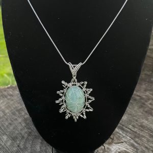 Aquamarine Cabochon stone with silver colour wire. The pendant shape is like a star